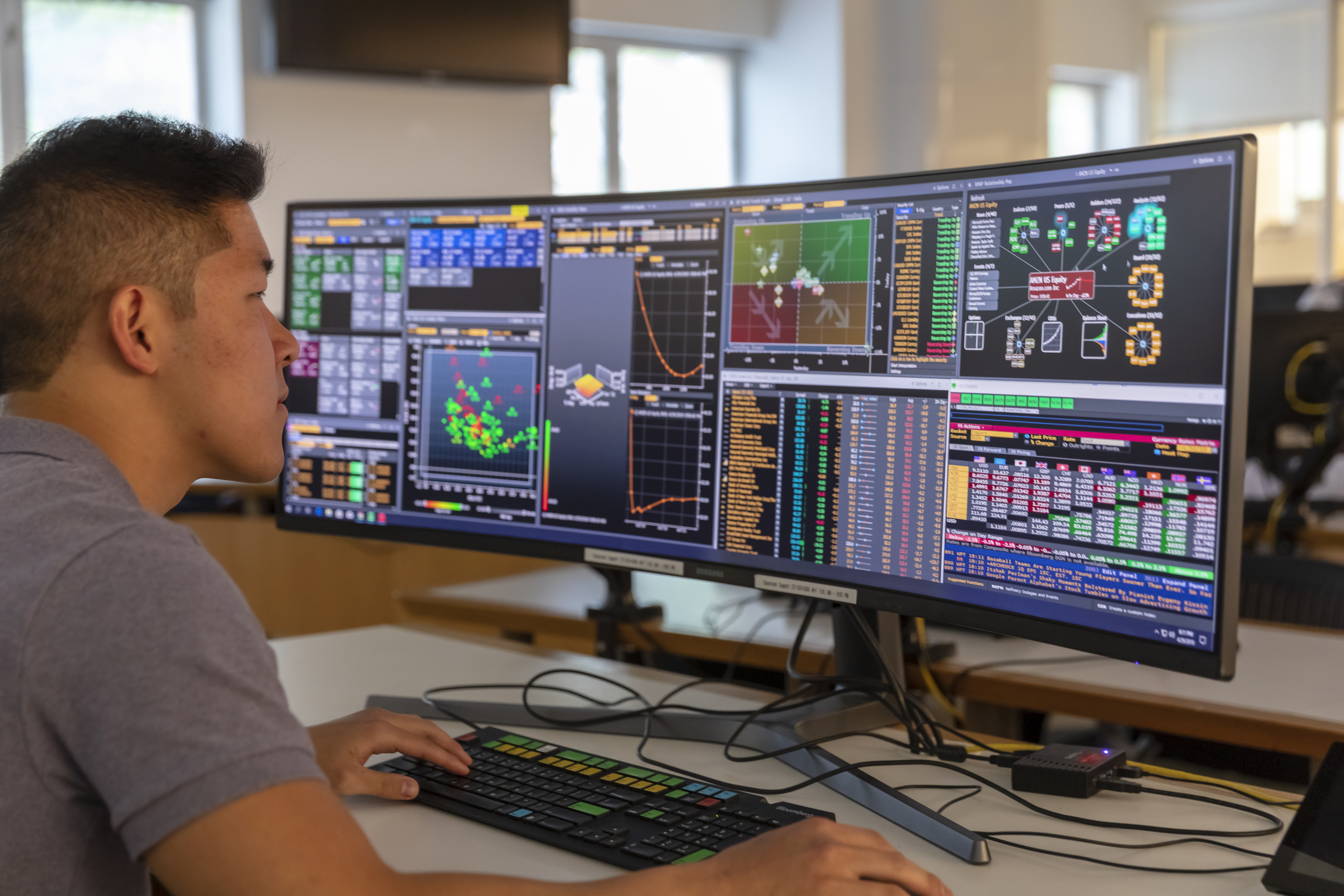 A student at Gies College of Business work at a large computer screen